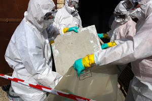 Staff removing some asbestos in a post of transformer, Reflection of mask of man opposite was created for cannot be recognized