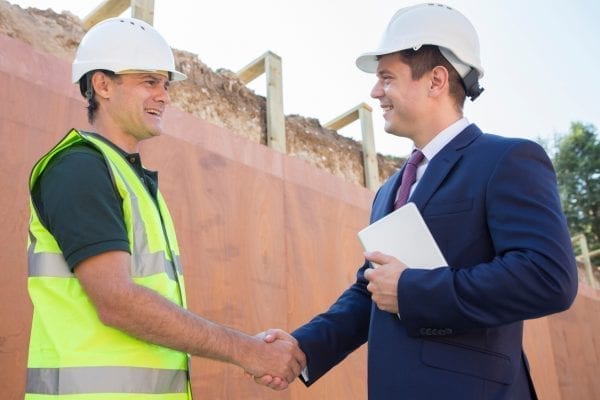 PCR construction worker and man in suit shaking hands