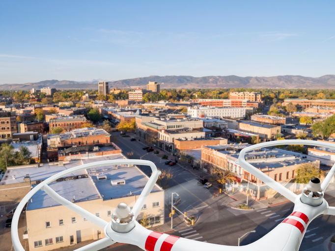 drones view flying over town with mountains