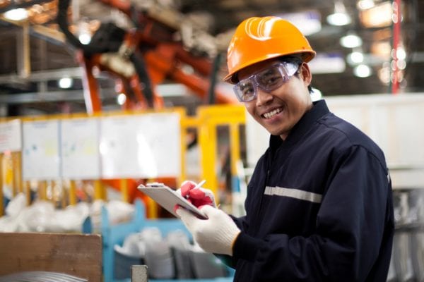 Industrial Hazards man with hard hat and clipboard in factory