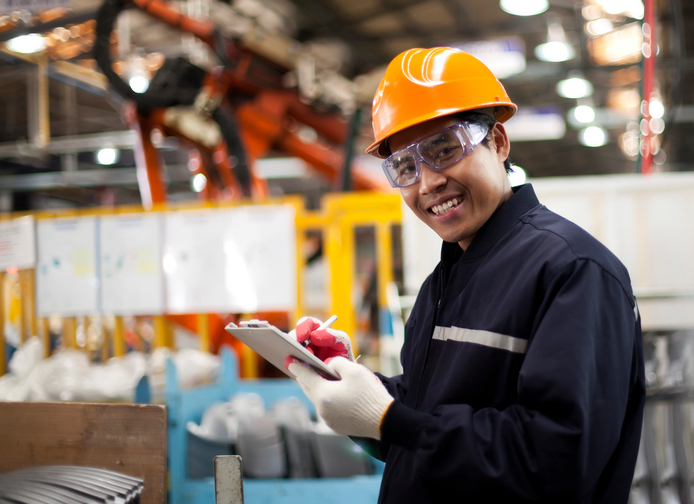 Industrial Hazards man with hard hat and clipboard in factory