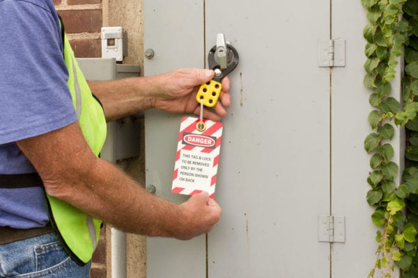 man holding a lockout/tagout sign